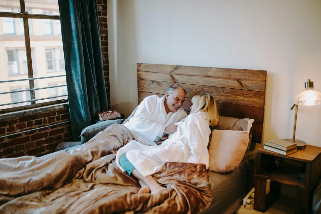 Senior couple enjoying a cozy moment together in a modern bedroom setting.